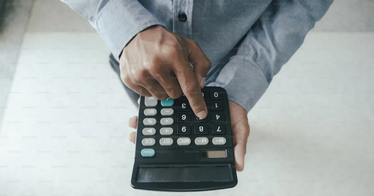 Calculator and laptop showing virtual assistant salary breakdown in Philippine pesos