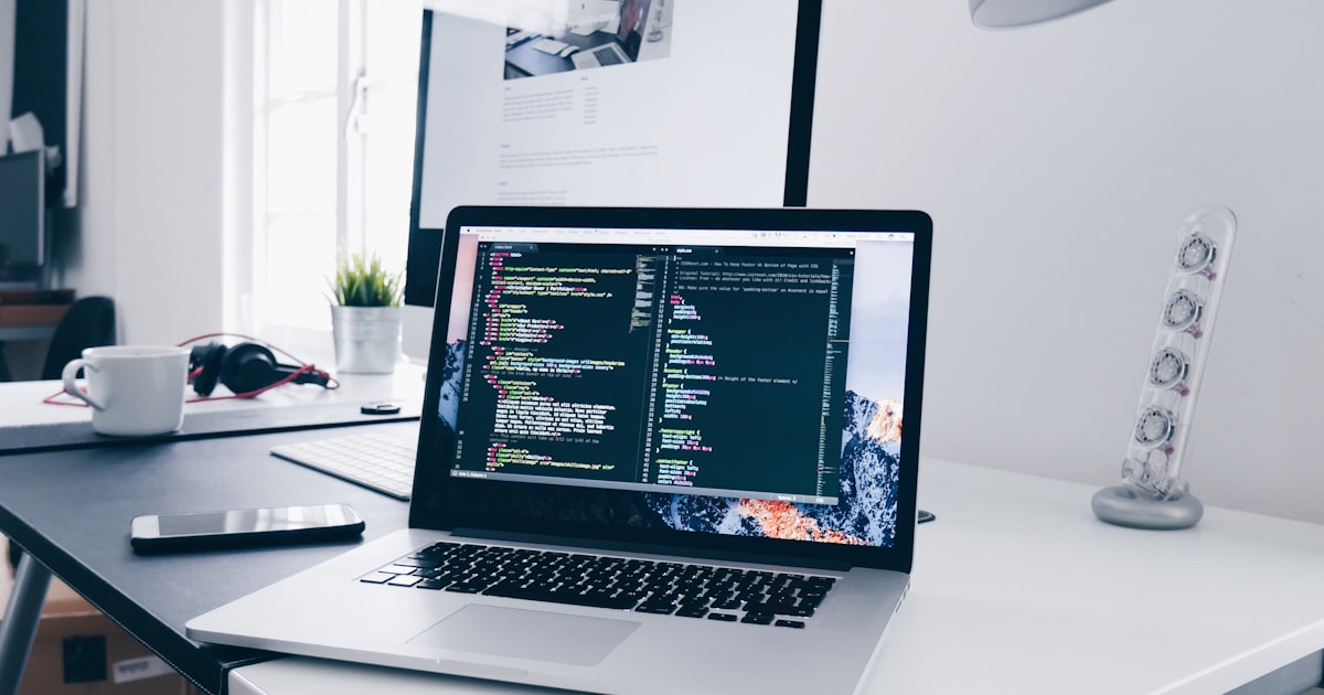 Developer working on an ecommerce website with Abu Dhabi skyline visible through office window