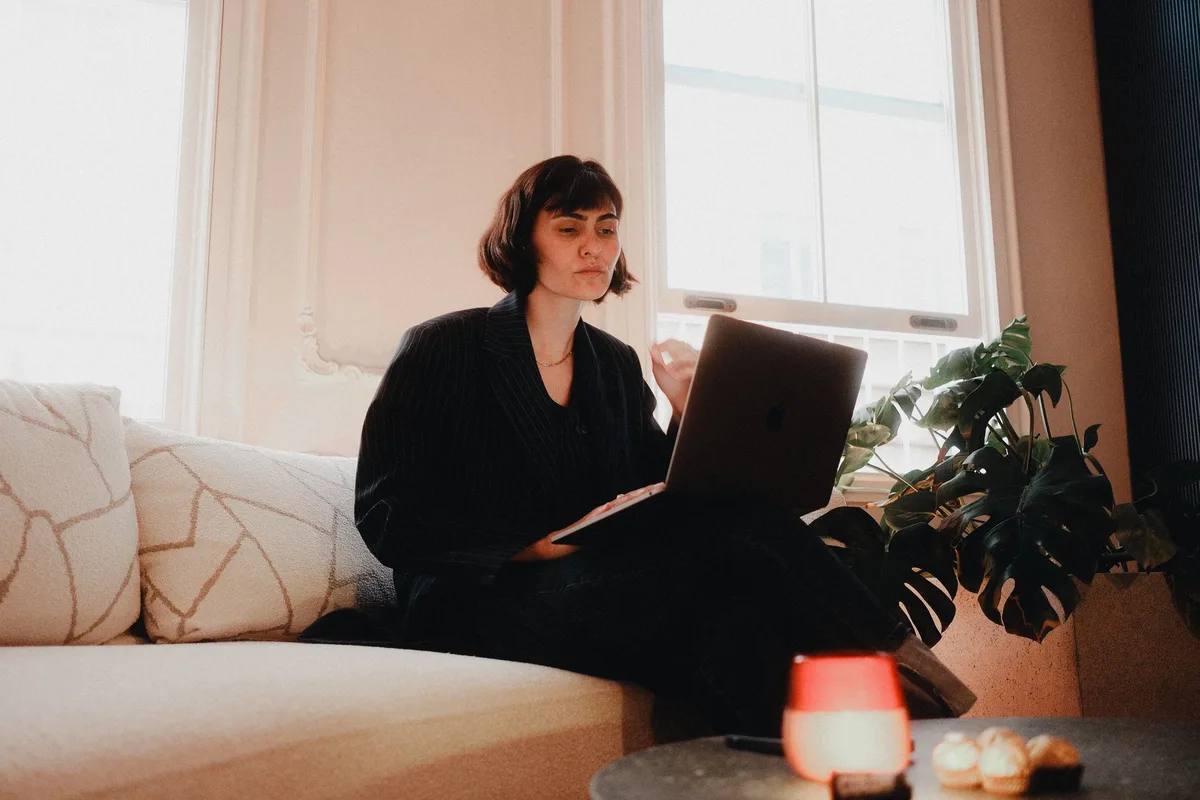 Woman working on a laptop from a bright home office, representing an independent freelancer virtual assistant
