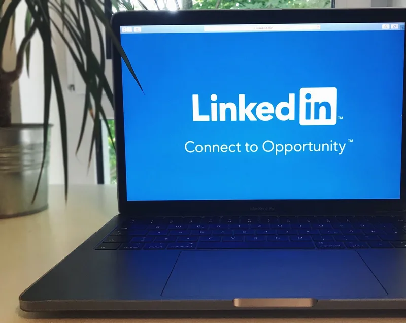 Laptop screen showing the LinkedIn homepage with the tagline “Connect to Opportunity,” representing a virtual assistant browsing job and career platforms