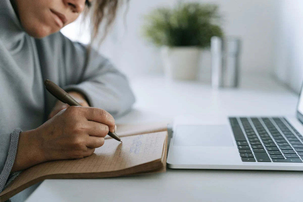 Filipino woman planning her virtual assistant career on a laptop at a home desk