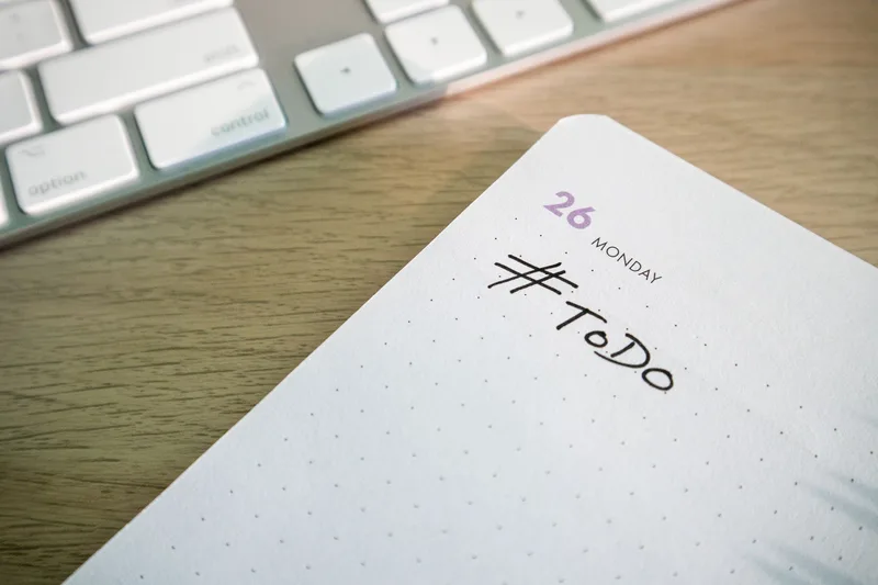 Close-up of a to-do list next to a computer keyboard on a desk