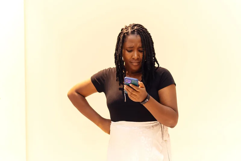 Person looking closely at a phone screen with a concerned expression