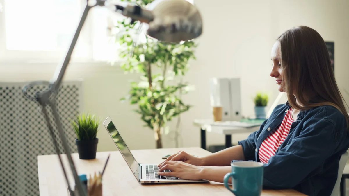 Woman working on a laptop at a home desk, representing an ecommerce virtual assistant managing a marketplace store