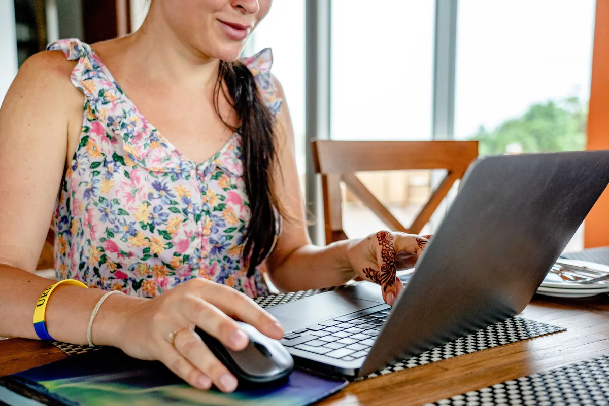 Woman using a laptop at home while researching virtual assistant job opportunities