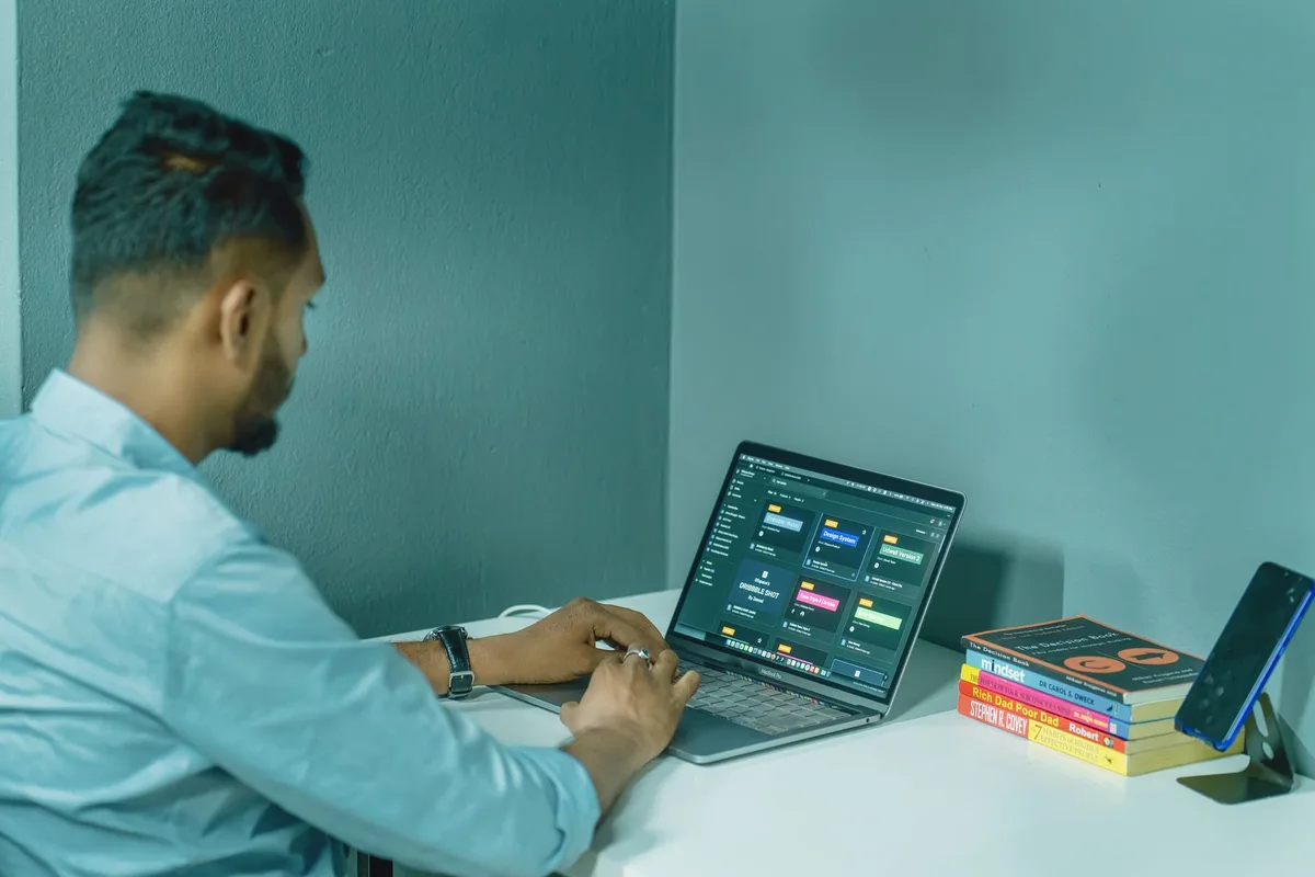 Remote worker at a home office desk managing virtual assistant tasks on a laptop
