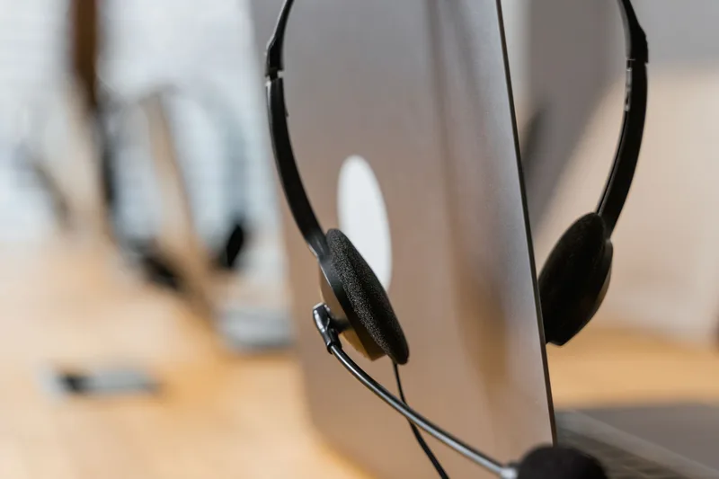 Headset resting on a laptop, representing VA chat and customer service work tools