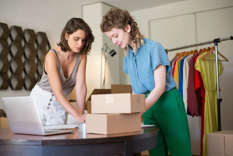 Two people packing boxes for an e-commerce order fulfillment project