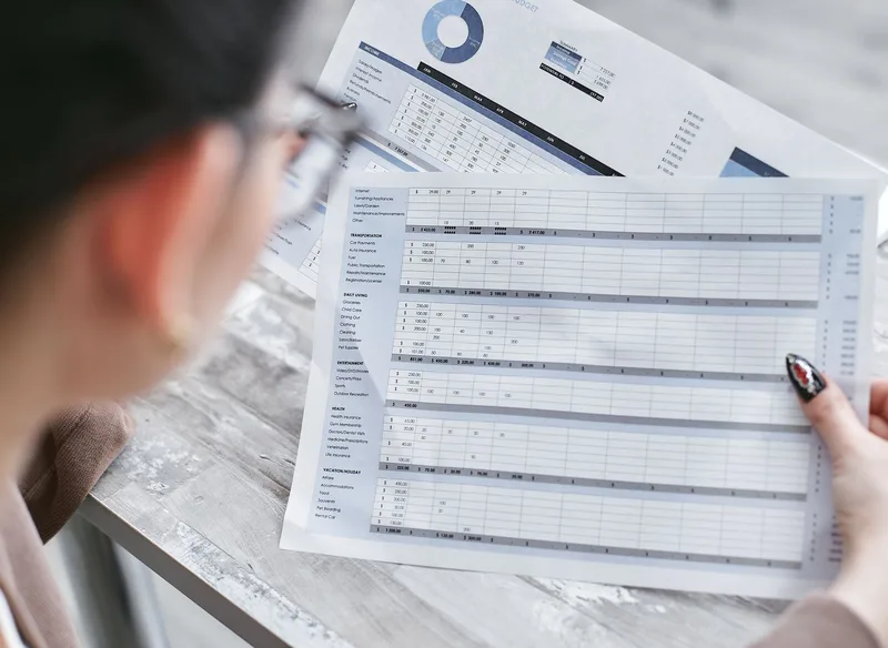 A remote worker reviewing spreadsheets and documents at a desk