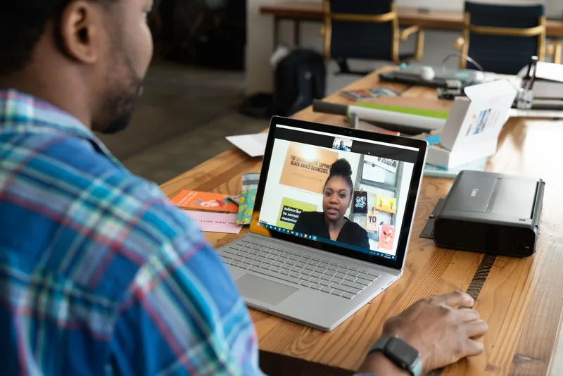 Virtual assistant on laptop attending online meeting with client